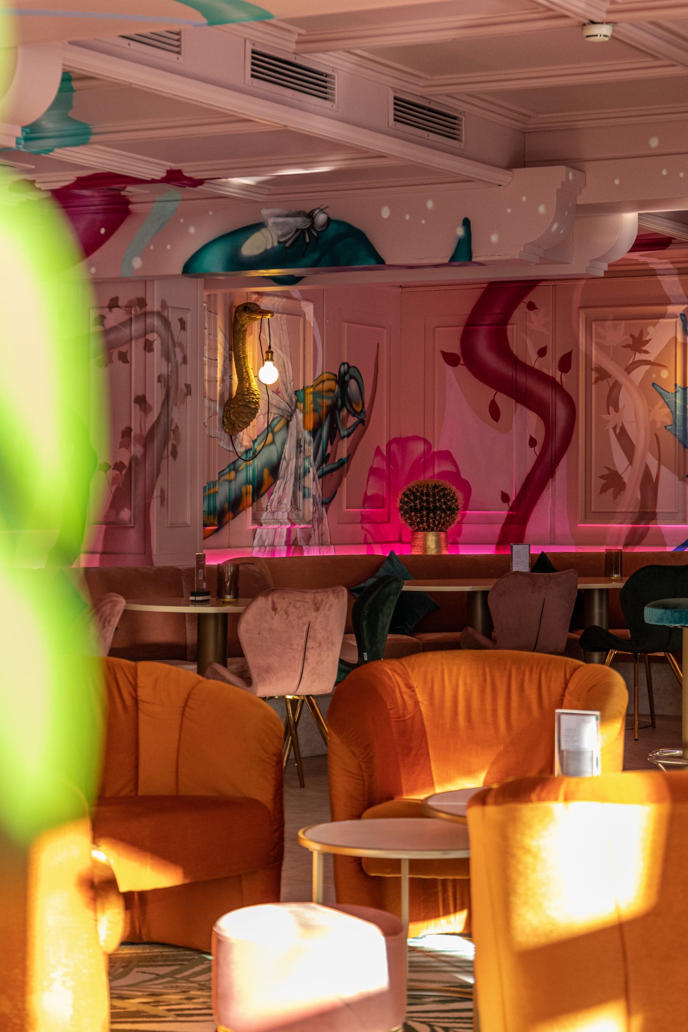 Die Lounge des Saalbacher Hofs in Pink und Orange, Wandmalerei mit Insekten
