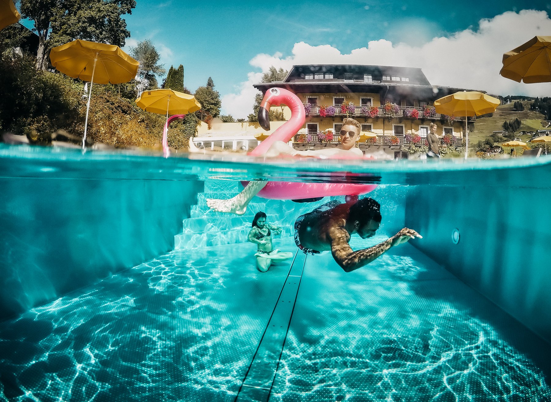 Flamingo über Wasser, Taucher darunter – Außenpool des Saalbacher Hofs