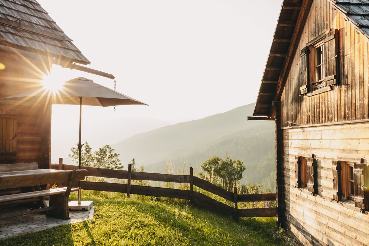 Terrasse einer Hütte im Gegenlicht mit Blick ins Tal