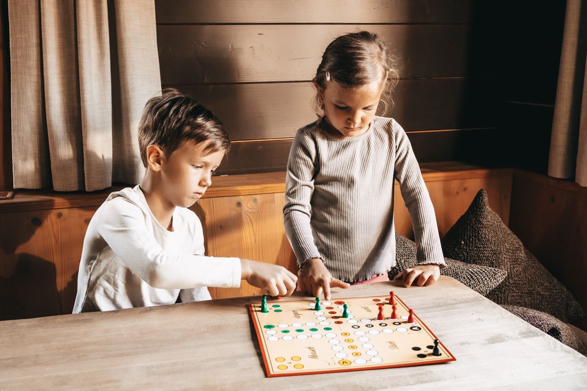 Familie beim Brettspiel in der Hütte