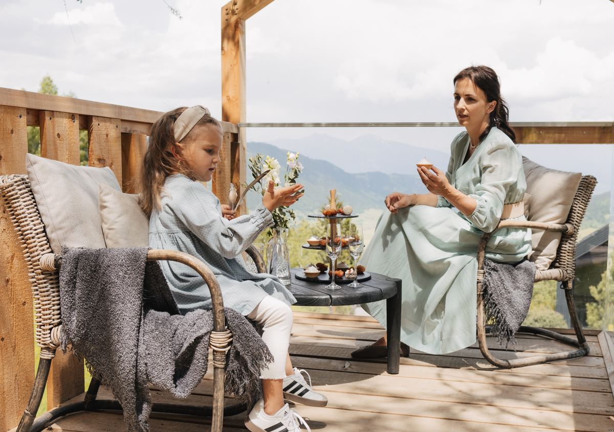 Zwei Frauen auf der Hüttenterrasse mit Blick ins Tal